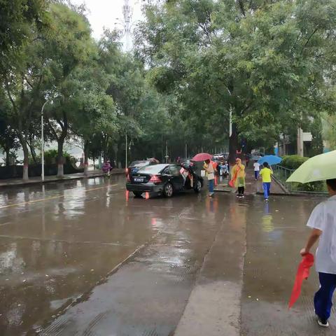 雨中的守护，天使的翅膀——秋风冷雨中，志愿爱心守护，微笑温暖你我，文明入校行二（3）班志愿服务