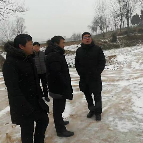 大峪镇中心校校长姚武超顶着严寒、冒着风雪到龙王规划中心小学建设