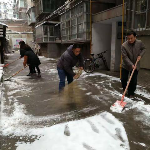 育华社区工作人员清理积雪中