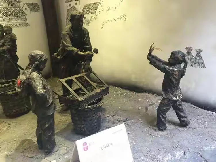 古镇街上的红糖艺术馆通过雕塑再现了甘蔗的种收，红糖制作及鸡毛换糖的艰辛。