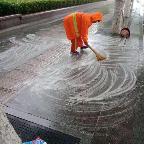 环卫工人借雨水洗刷路面