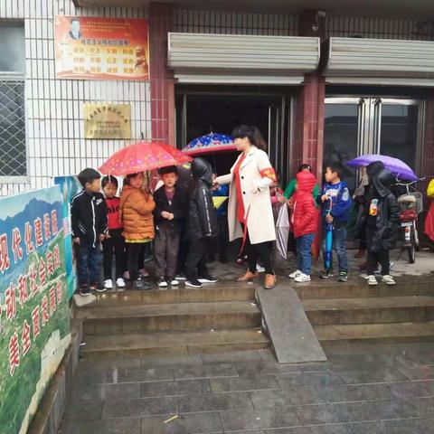 梁召学区大姜村学校教师冒雨指挥交通