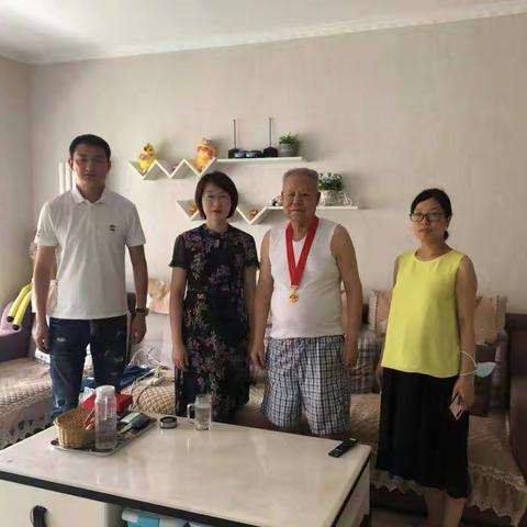太乙路街道副主任季冬玲上门为北沙社区党支部行动不便老党员颁发“光荣在党50年”纪念章