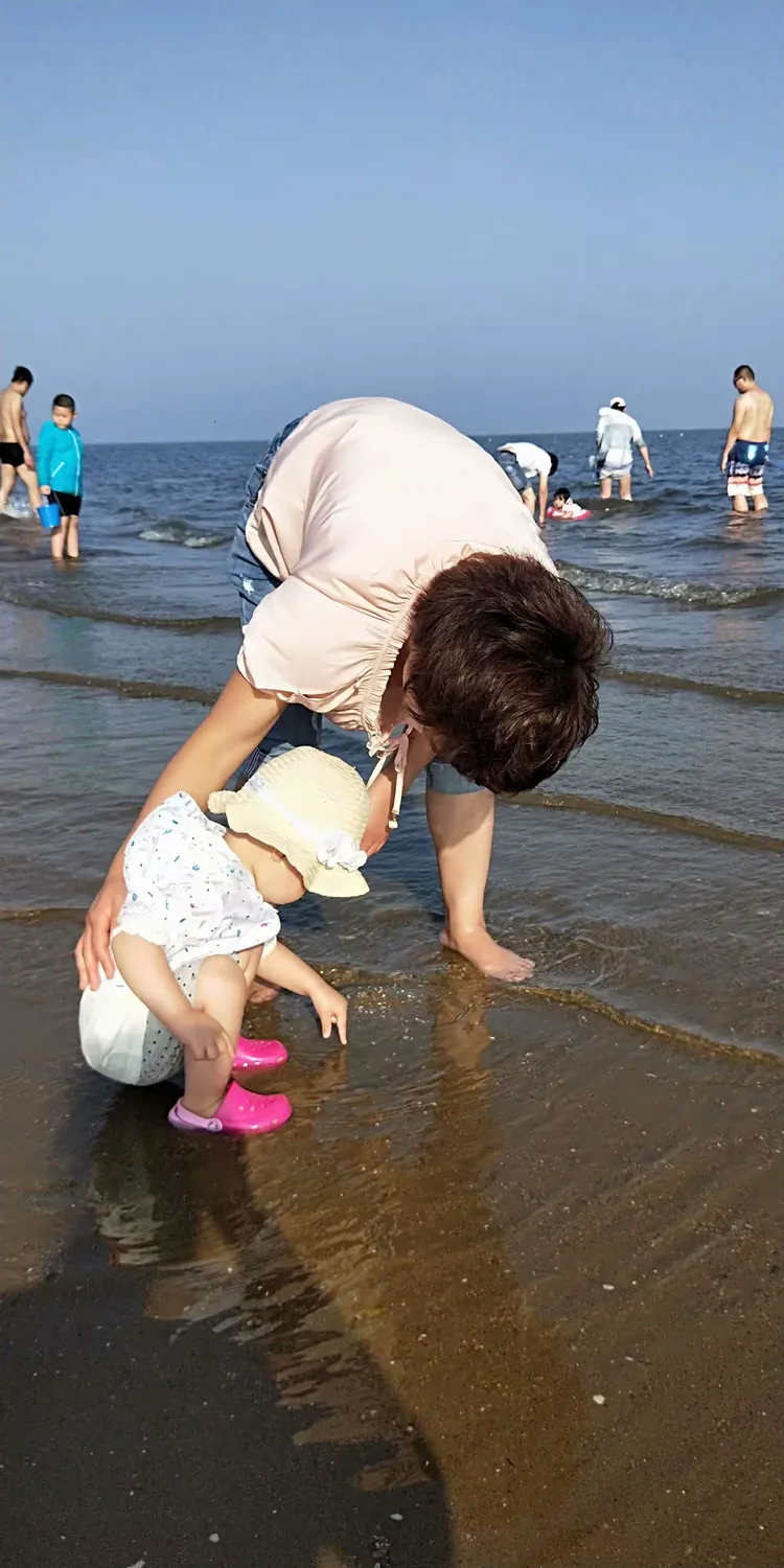海边水里捉鱼呢