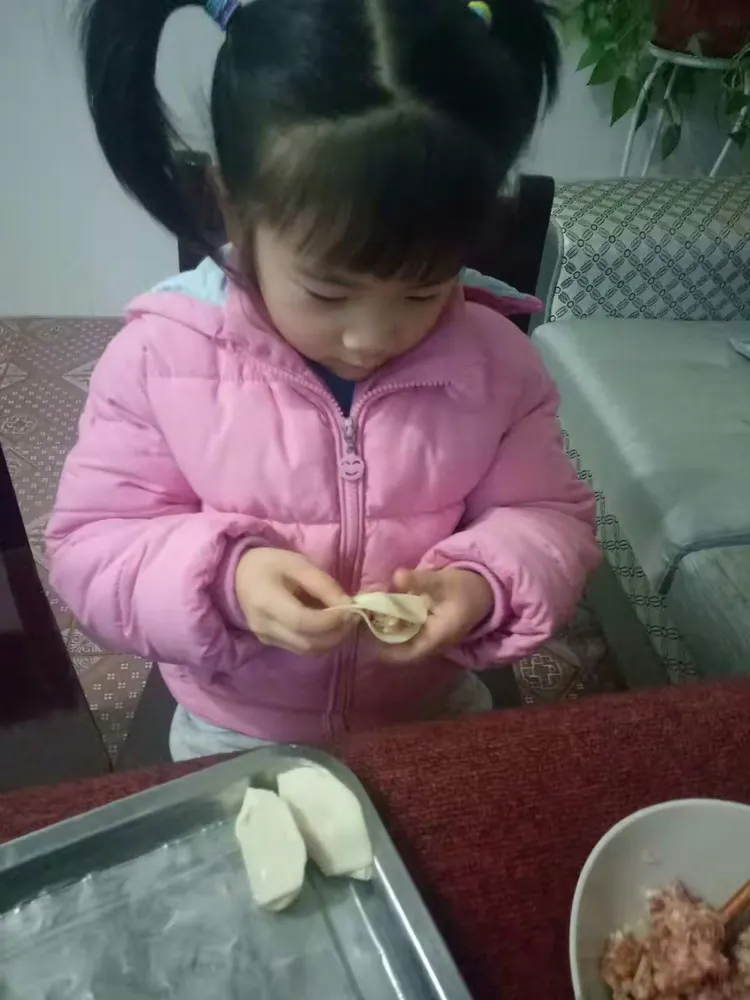大年三十,奶奶教忻忻包饺子,忻忻学得特别认真,还能自己包呢。