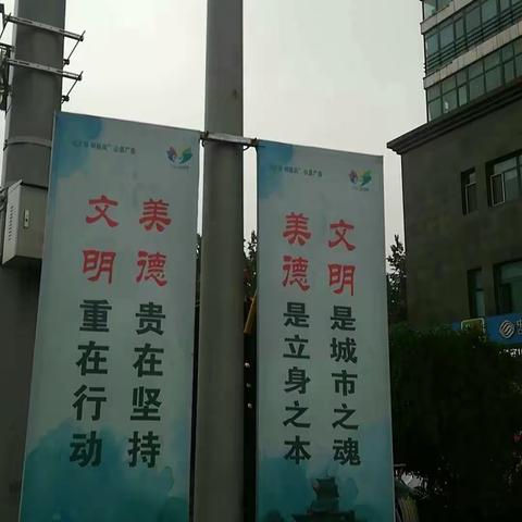 天桥东街冒雨拆除灯杆道旗、收费公示牌及绿化带灯箱广告