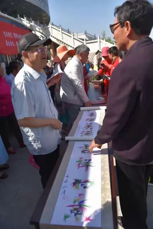 喀喇沁旗民间故事传承人国占云与观众互动，观众纷纷抢购他的书籍。