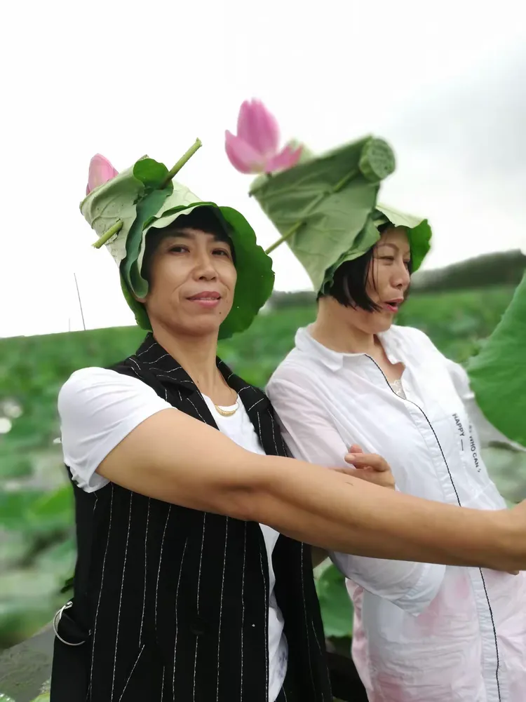 船家姐姐帮我们每人做了一顶荷叶帽子，我顺手插了一朵荷花，戴上是不是很美！