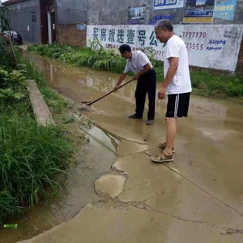 菜园集镇袁老家村网格员雨后清理路面积水，并做好排水工作