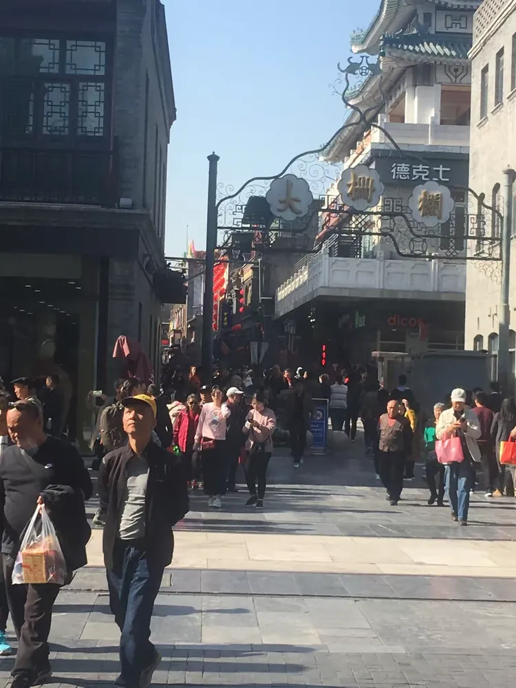 步行街里游人熙熙攘攘，摩肩接踵。