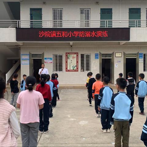 做细做实疫情防控，共同守护师生健康。——茂名市沙院镇五和小学于3月18日开展疫情防控应急演练。