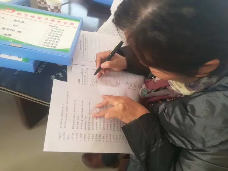 包户干部对贫困户资料进行完善 ，核对有关数据。