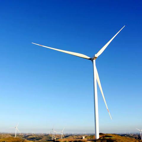 陇西县宏伟乡境内，通体洁白的风电机塔，错落耸立在山脊之上，巨大的风叶迎风而动，风车与蓝天碧野交相辉映。