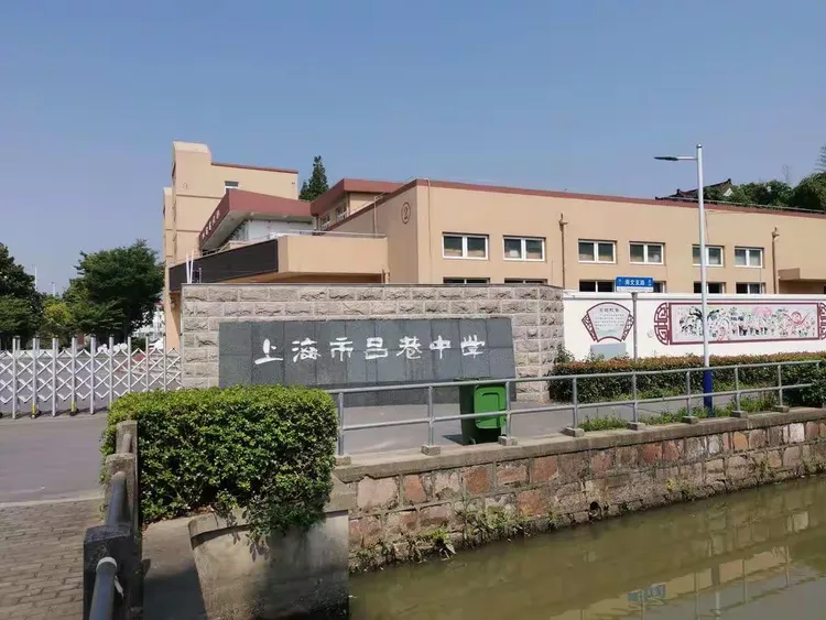 改建后吕巷中学大门朝东开同学们在母校大门外合影母校各种校徽母校