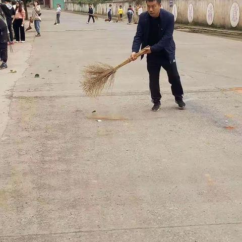 治理校园周边环境卫生——行廊九年制学校胡校长亲自率领全校教师打扫校园周边卫生