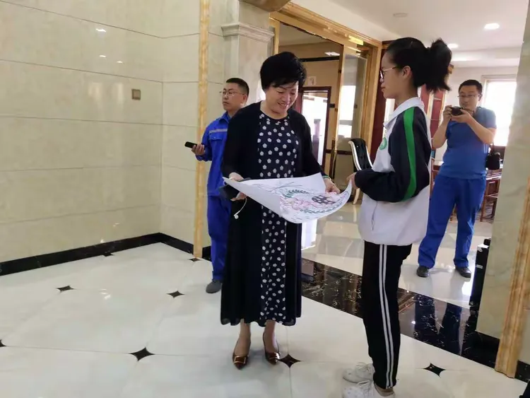 优秀学生代表刘剑梅向刘银娥董事长送上精心绘制的画作,祝愿刘银娥