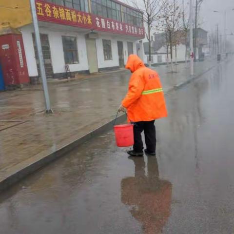 寒风冬雨中，国源公司保洁员冒雨坚持清理卫生。