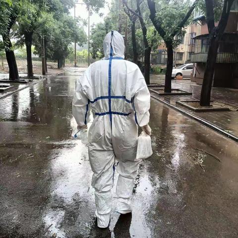 文北街道大洪桥第一社区工作人员及志愿者在雨中为居民采集核酸