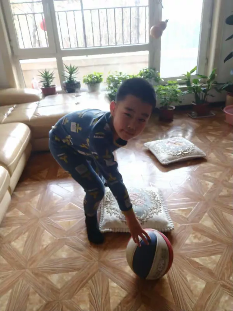 我在家里运动呢，正在玩篮球，长时间锻炼身体，会使身体更健康哦！